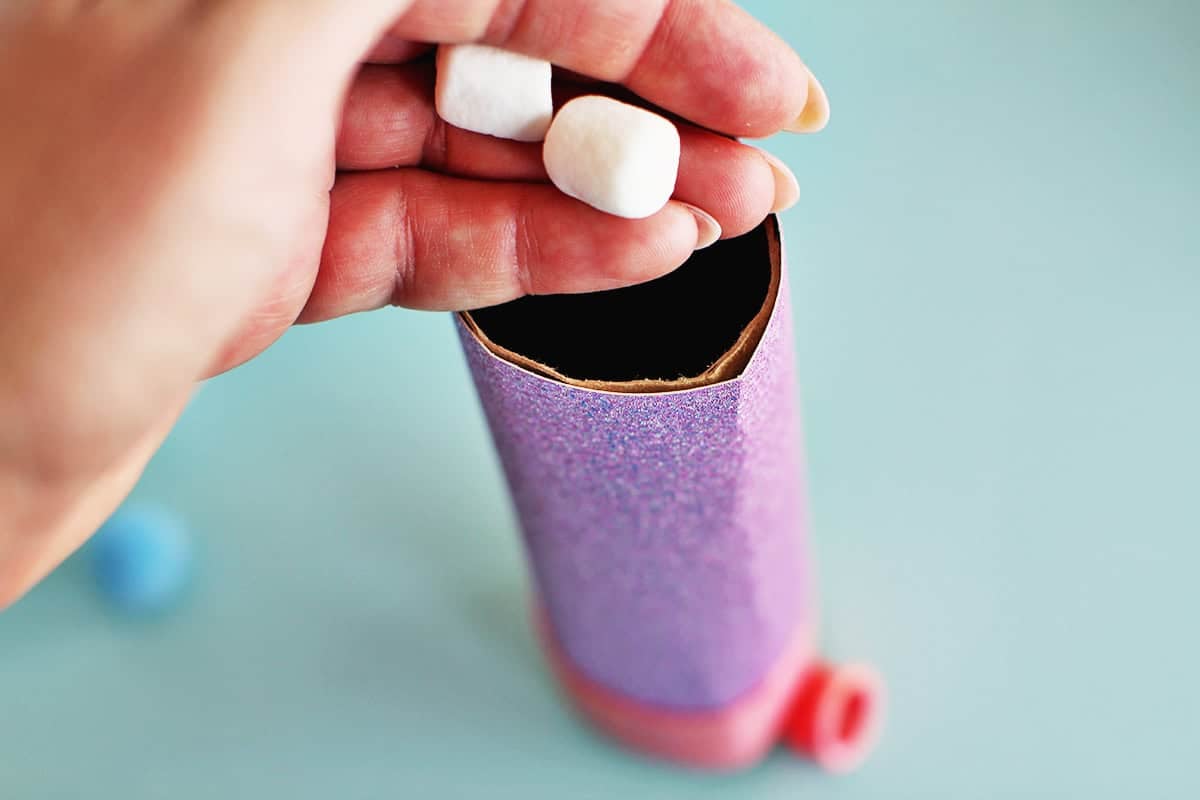 Adding marshmallows to homemade marshmallow shooter.