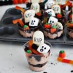 Pudding and crushed oreo cookies in a plastic cup to serve as a Halloween kids' dessert.