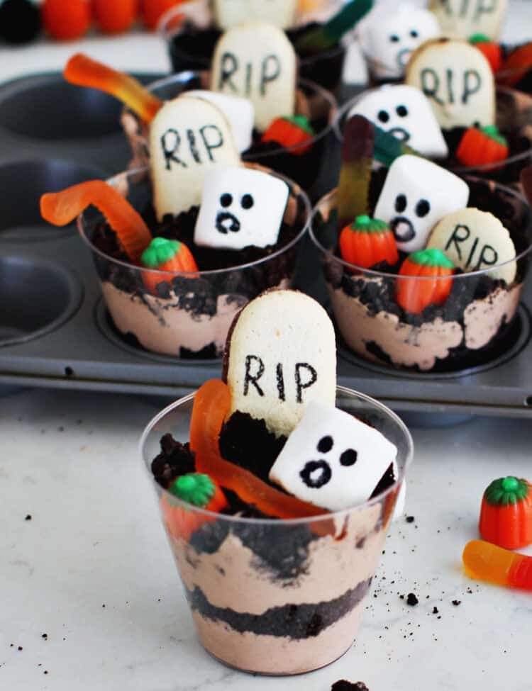 Pudding and crushed oreo cookies in a plastic cup to serve as a Halloween kids' dessert.