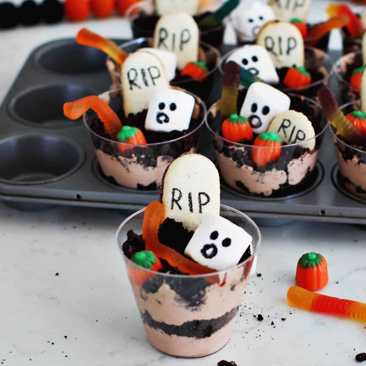Pudding and crushed oreo cookies in a plastic cup to serve as a Halloween kids' dessert.