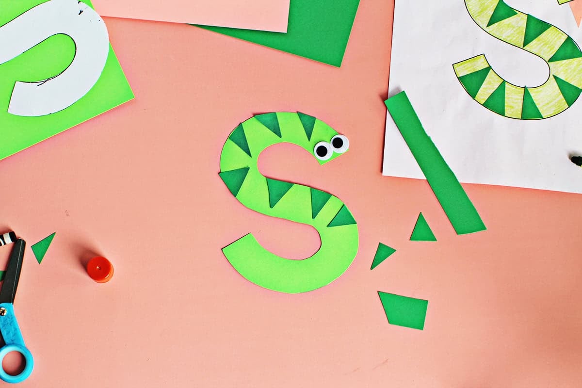 Adding stripes to a paper snake craft.