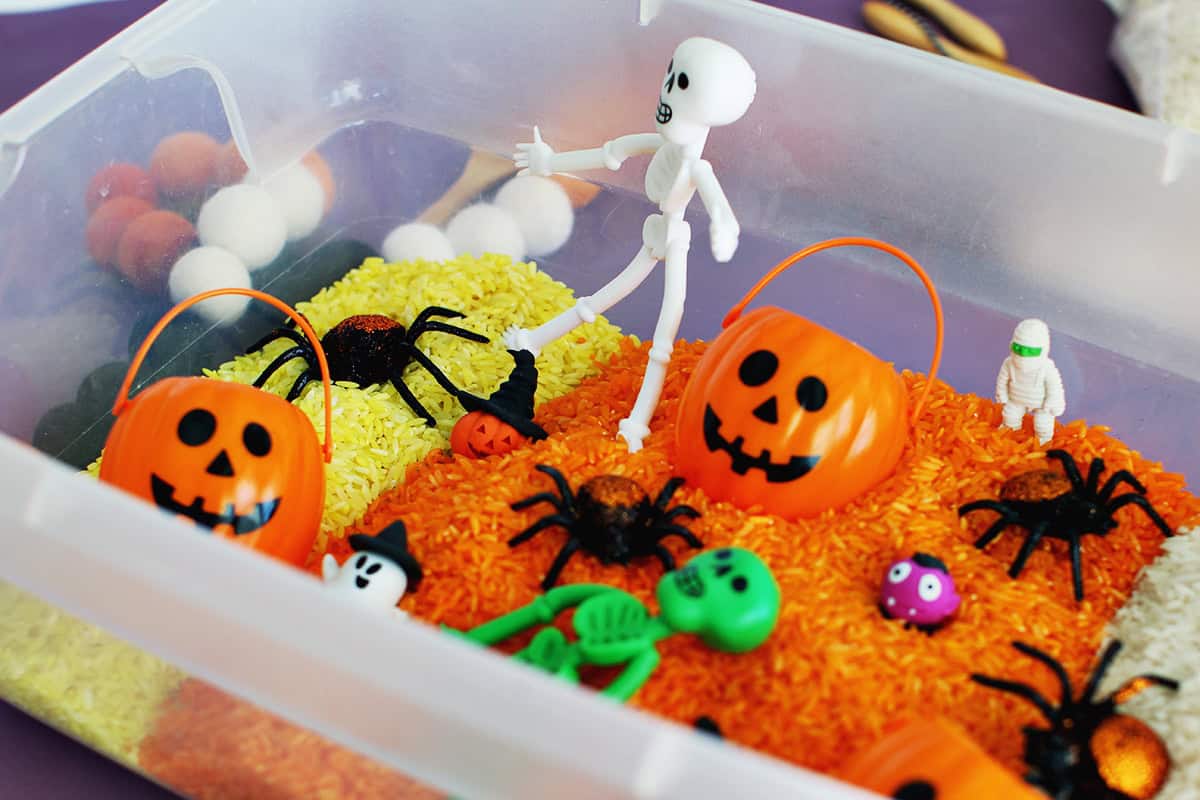 Halloween sensory bin filled with plastic toys.
