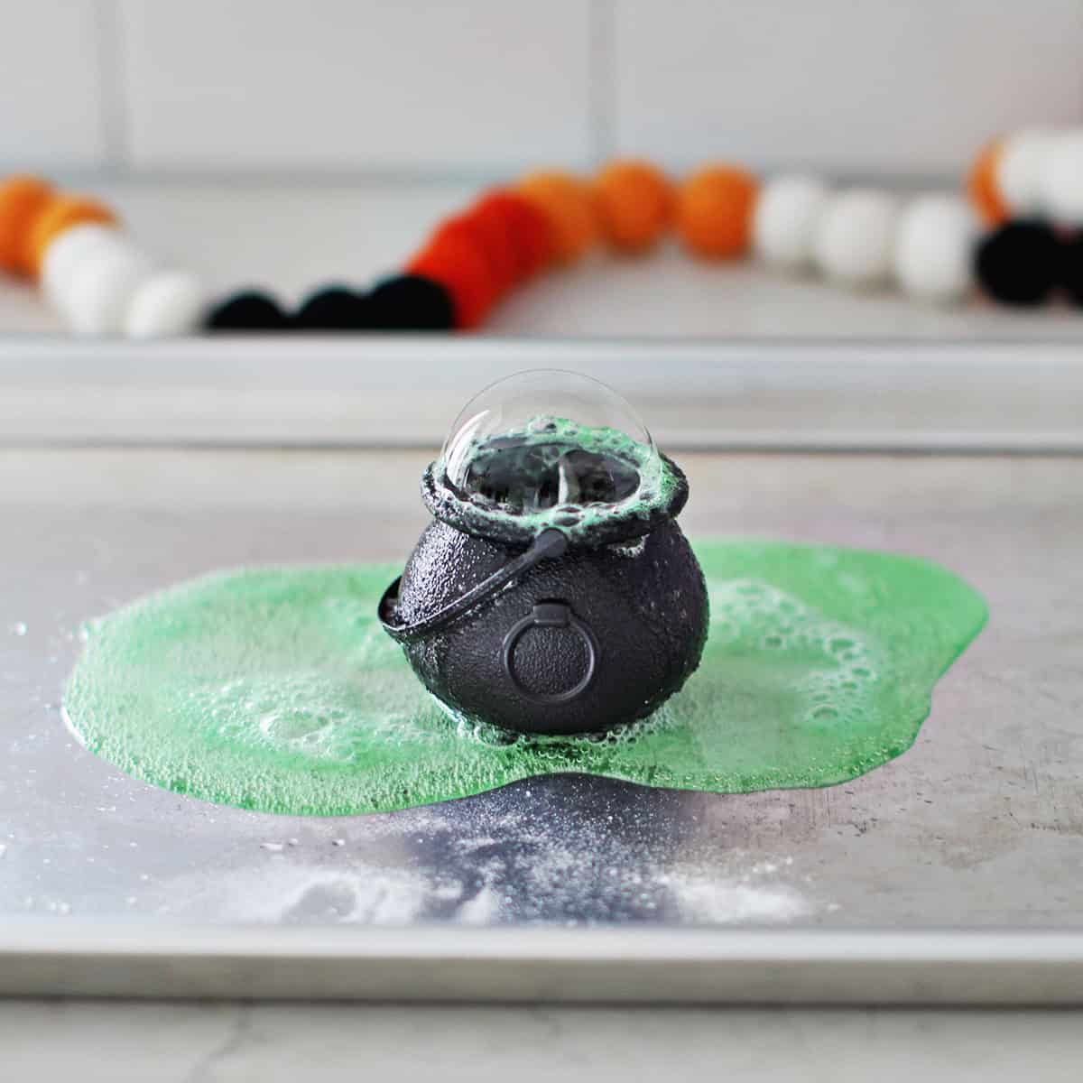 Baking soda and vinegar combined with green jello in a plastic cauldron.