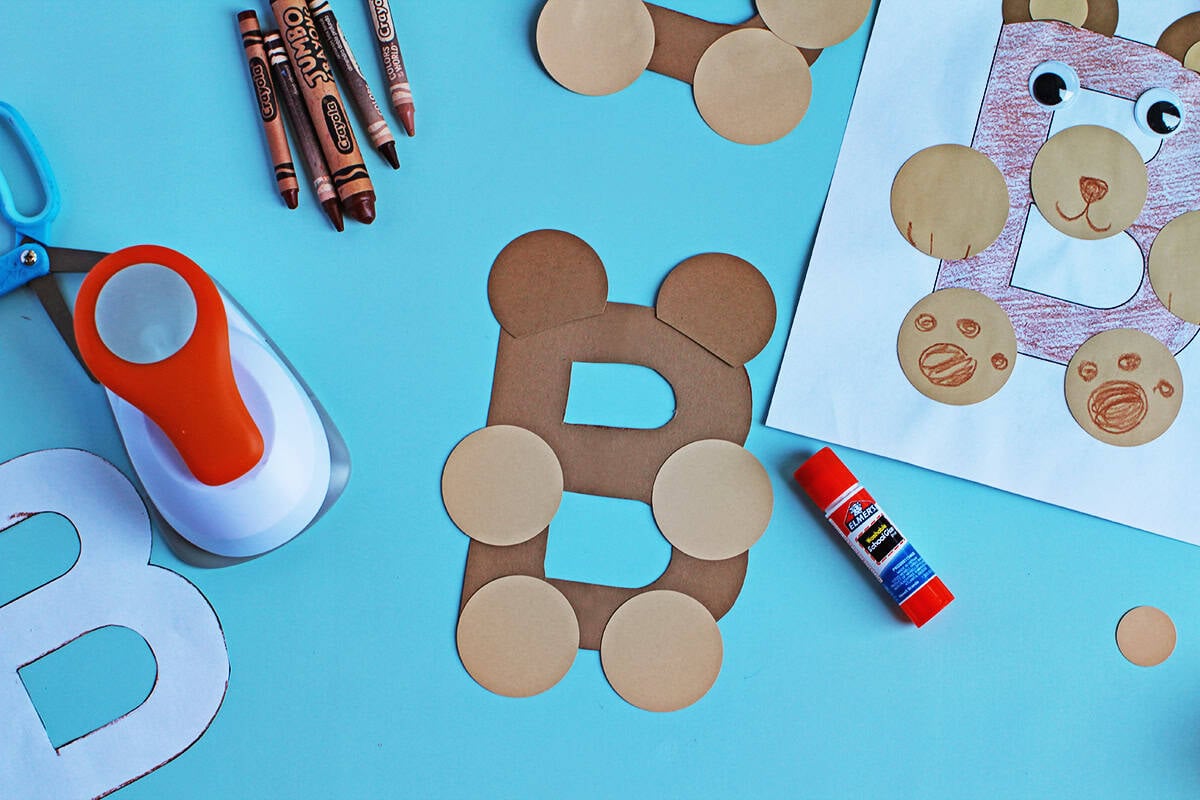 Circles being glued onto brown paper B to make a bear.