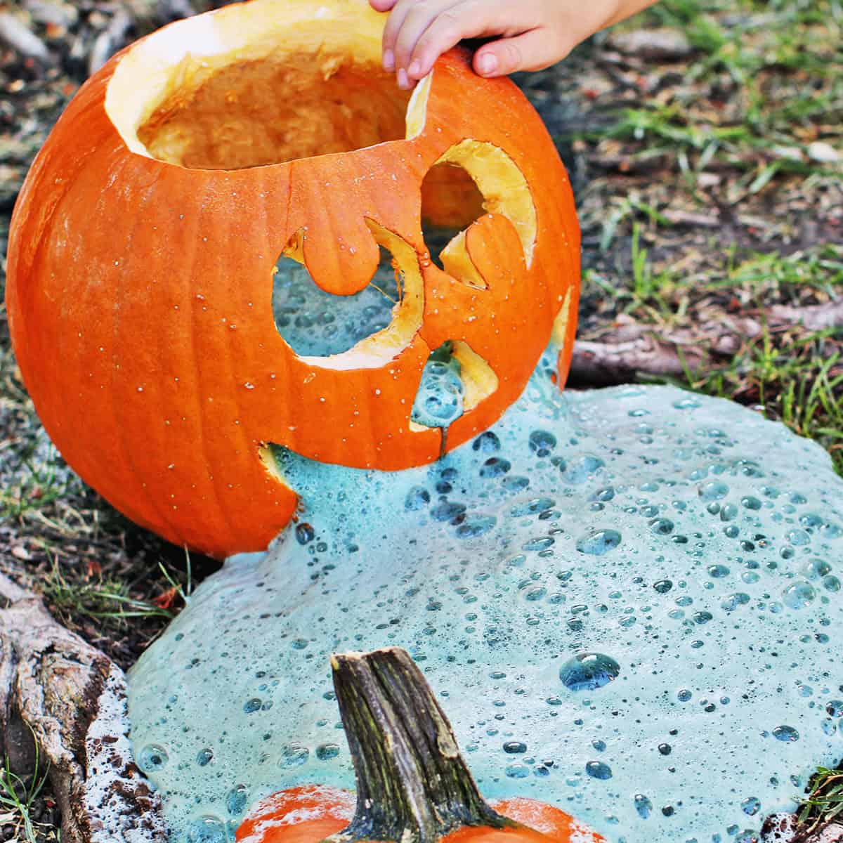 carved pumpkin with baking soda and vinegar combination coming out of it.