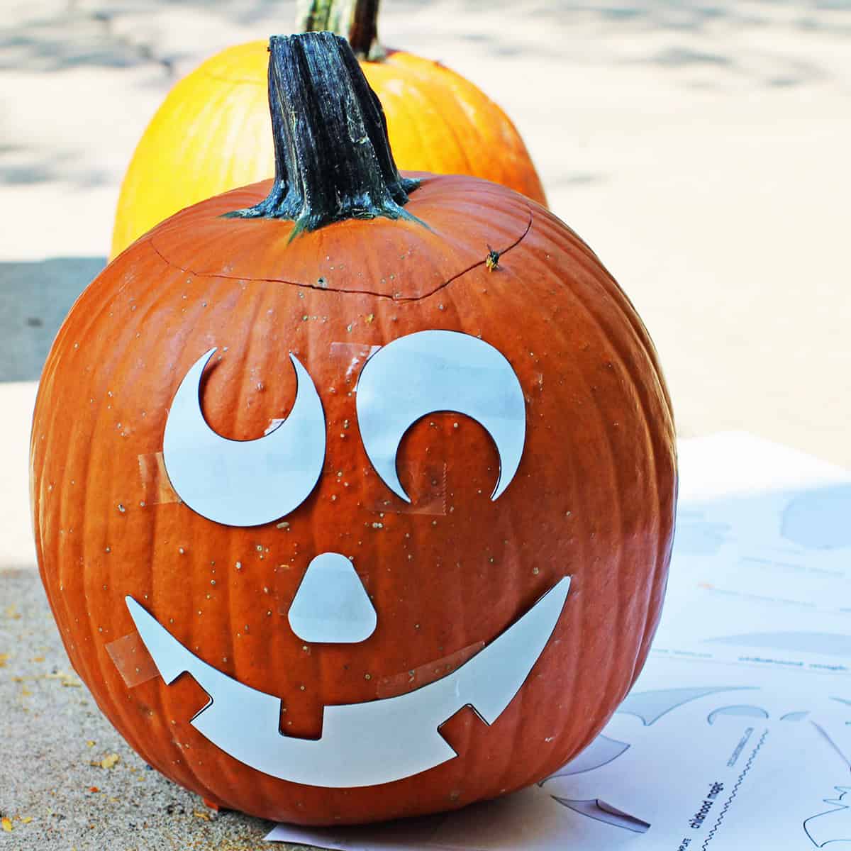 pumpkin with printed template cut out and taped to it.