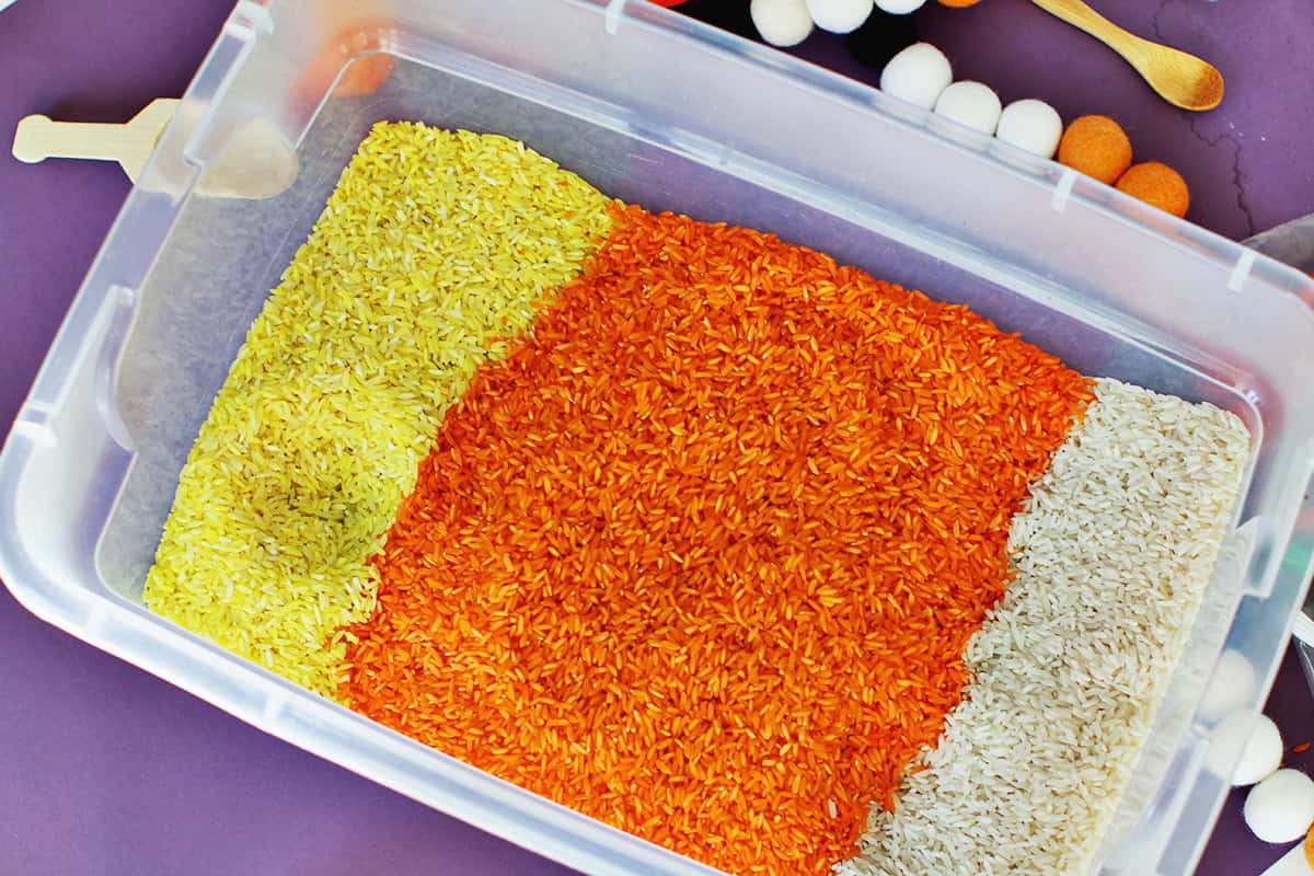 clear tote filled with yellow, orange and white rice to look like candy corn.