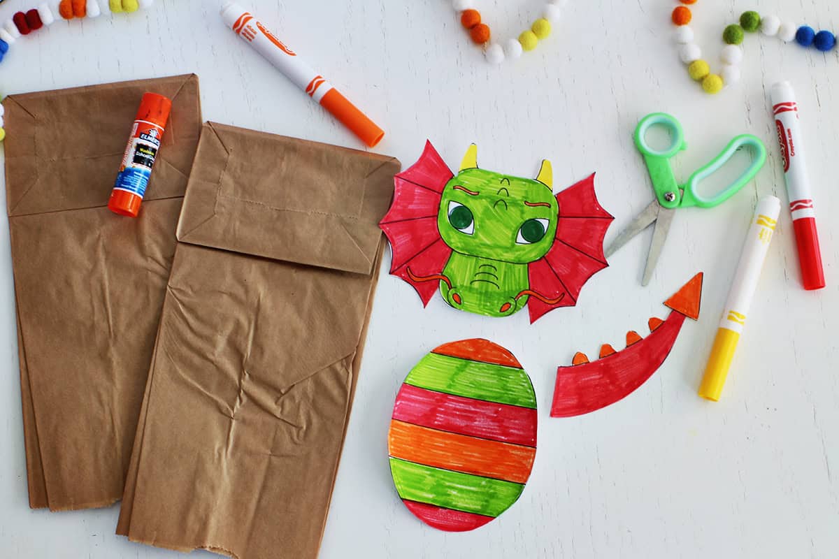 Paper bag puppet craft with printed and colored dragon pieces.