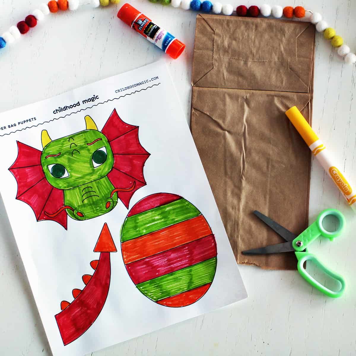 Paper with dragon head, belly and tail ready to cut out and glue to a paper bag to make a puppet.