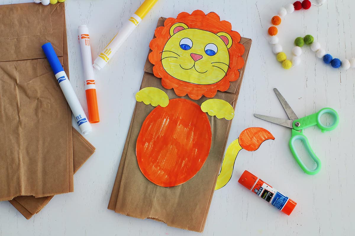 Paper bag with cut out and colored pieces glued onto it to make a lion puppet.