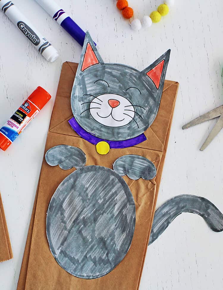 Paper bag puppet craft with a page colored in as a cat.