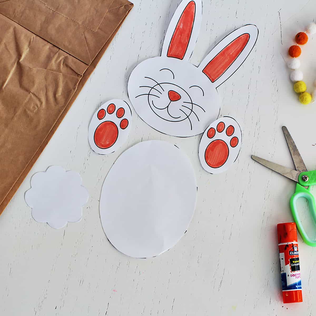 Rabbit face, paws, tail and stomach cut out and ready to glue onto a bag to make a puppet.