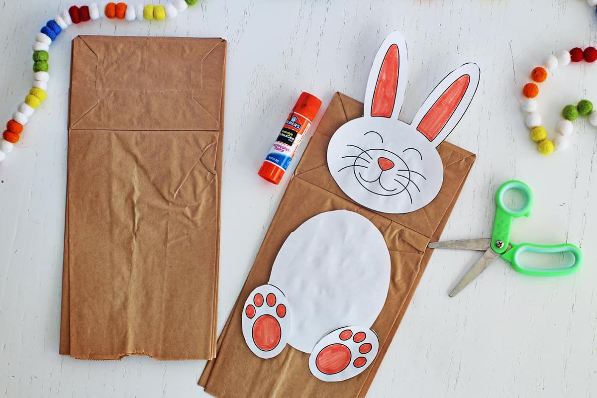 Paper bag with cut out and colored rabbit pieces.