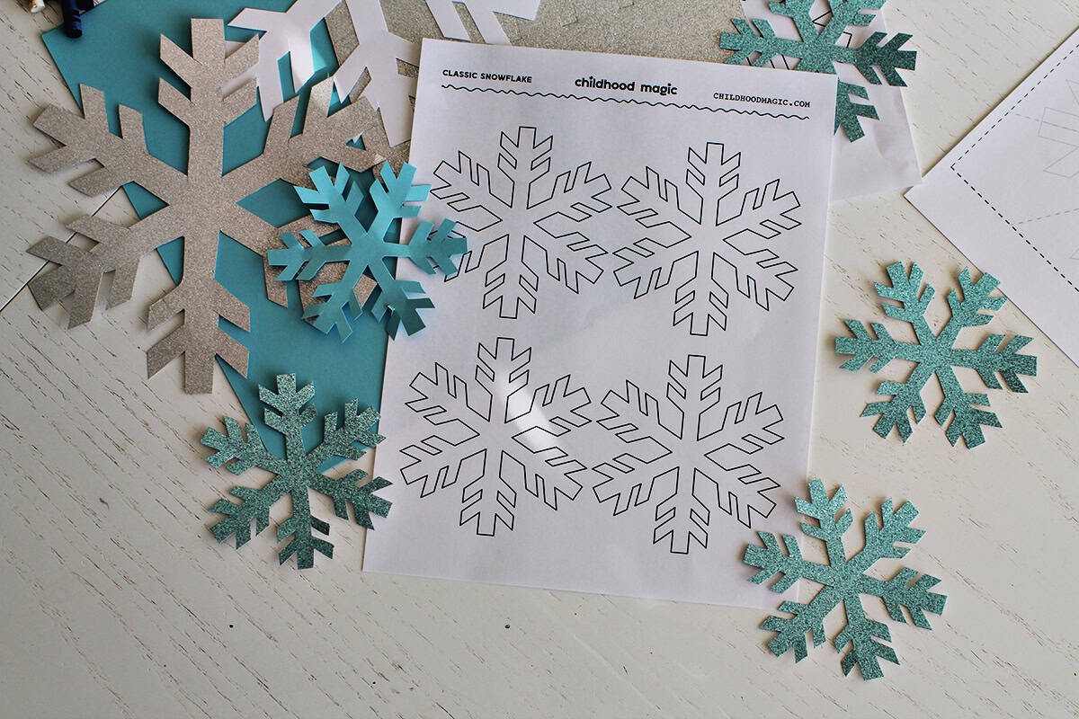 page with printed snowflakes next to cut out snowflake shapes.