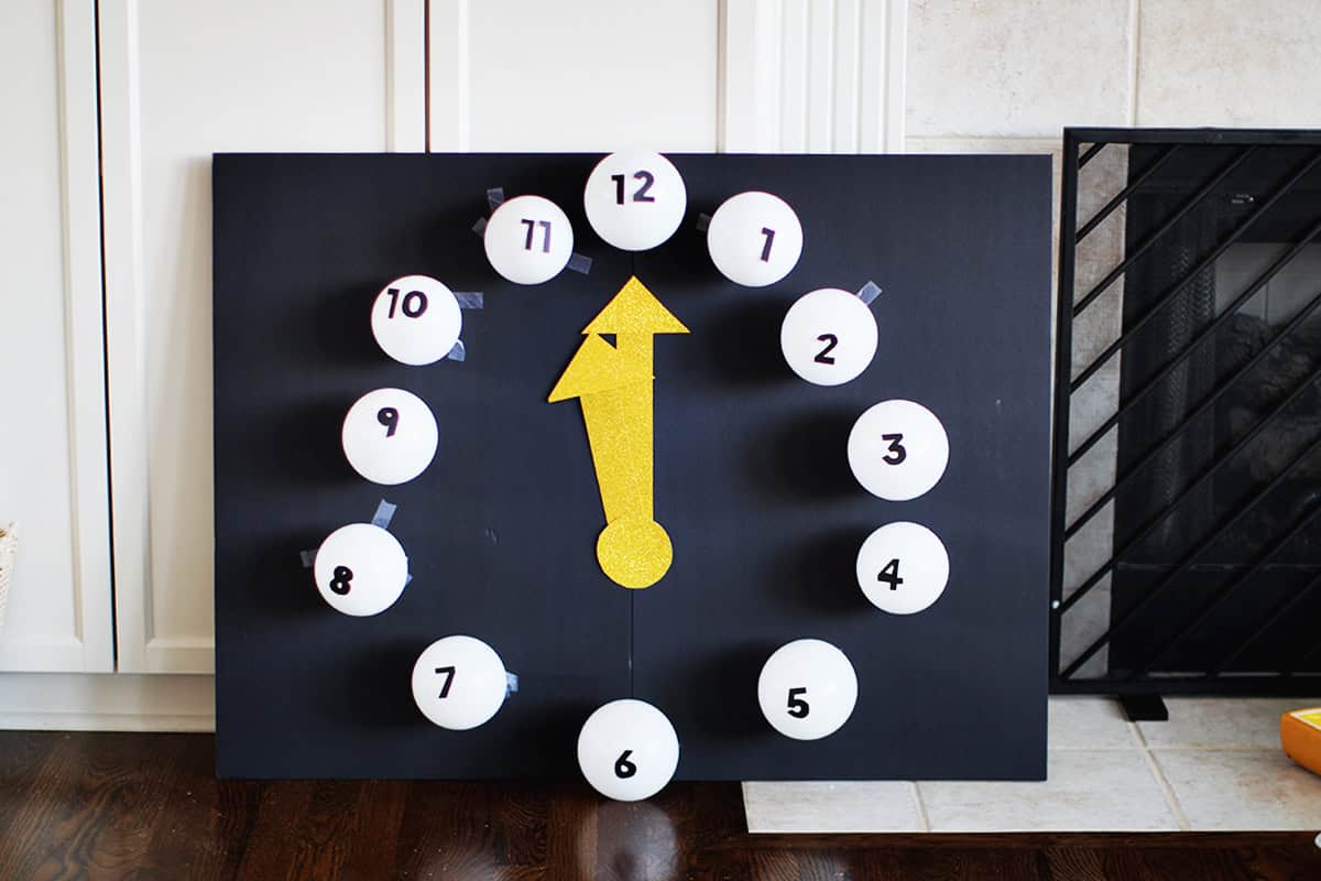 clock made from small white balloons with black cardstock numbers taped onto them.