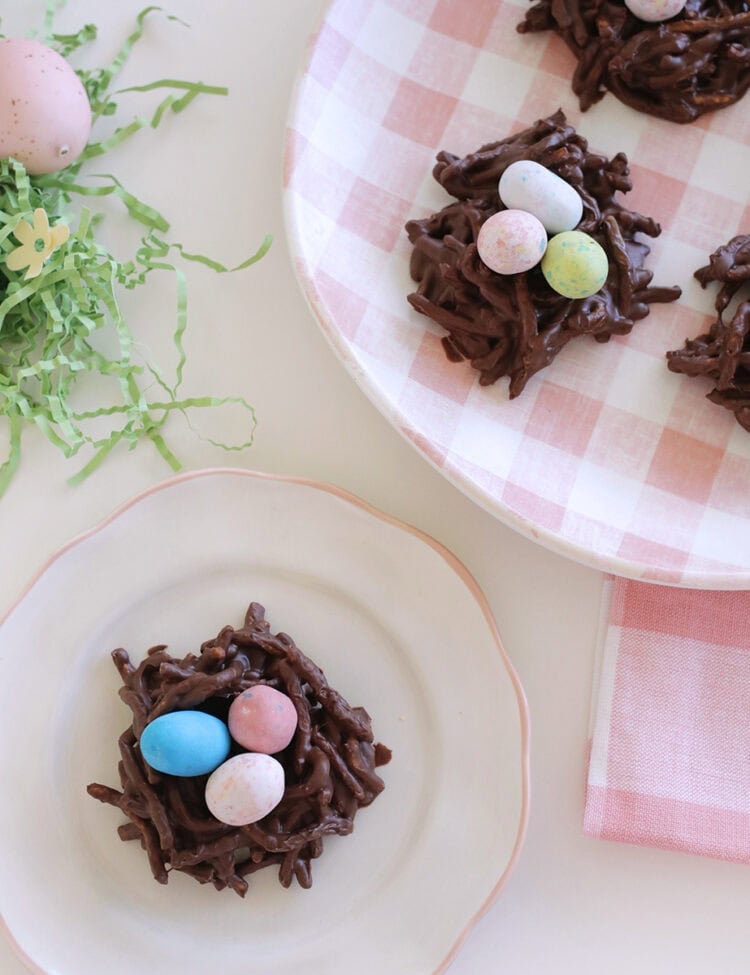 bird's nest cookies made from chow mein noodles and with candy eggs sitting on a plate.