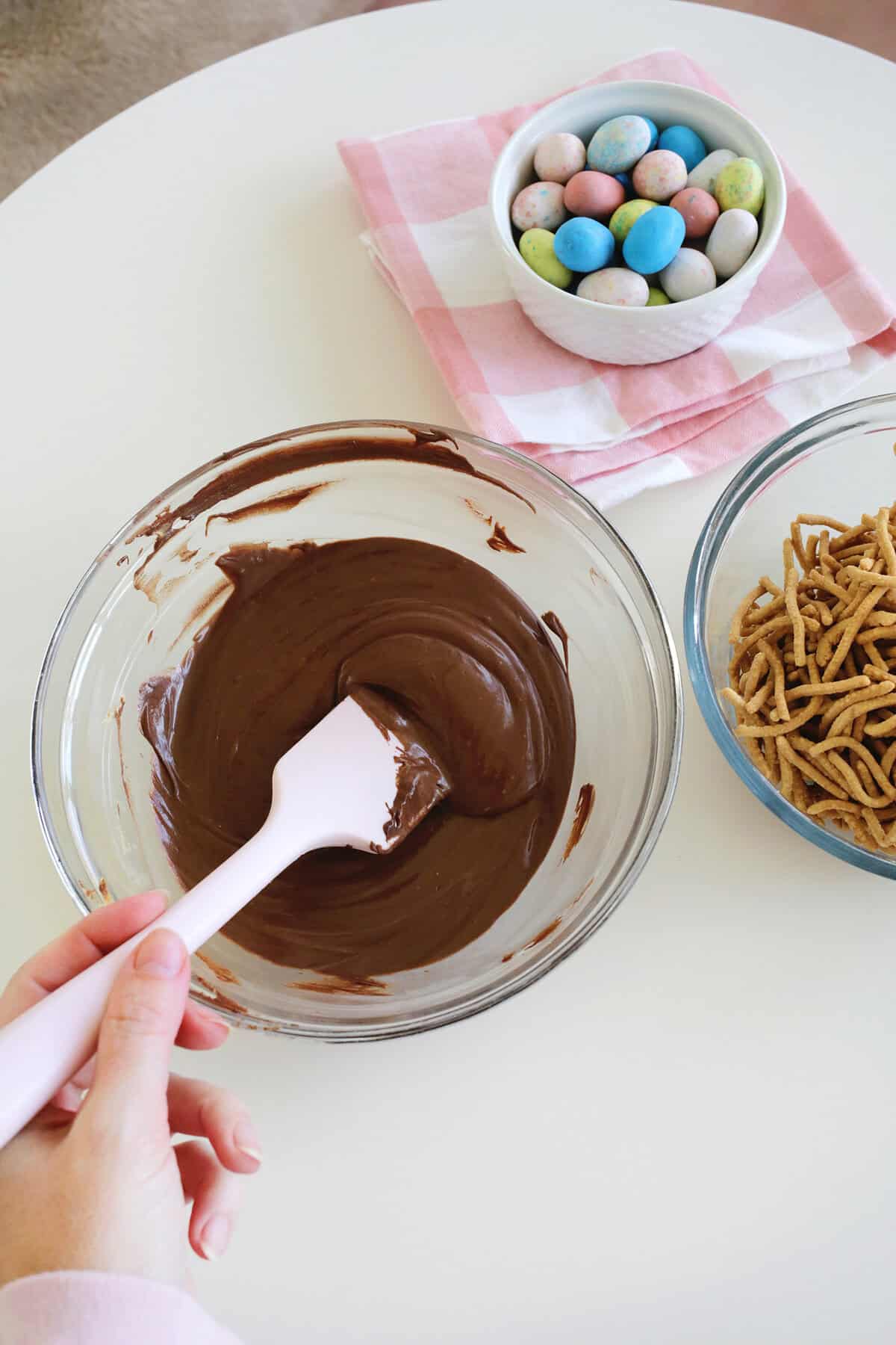 Bowl of melted chocolate chips and peanut butter chips being stirred together with a spatula.
