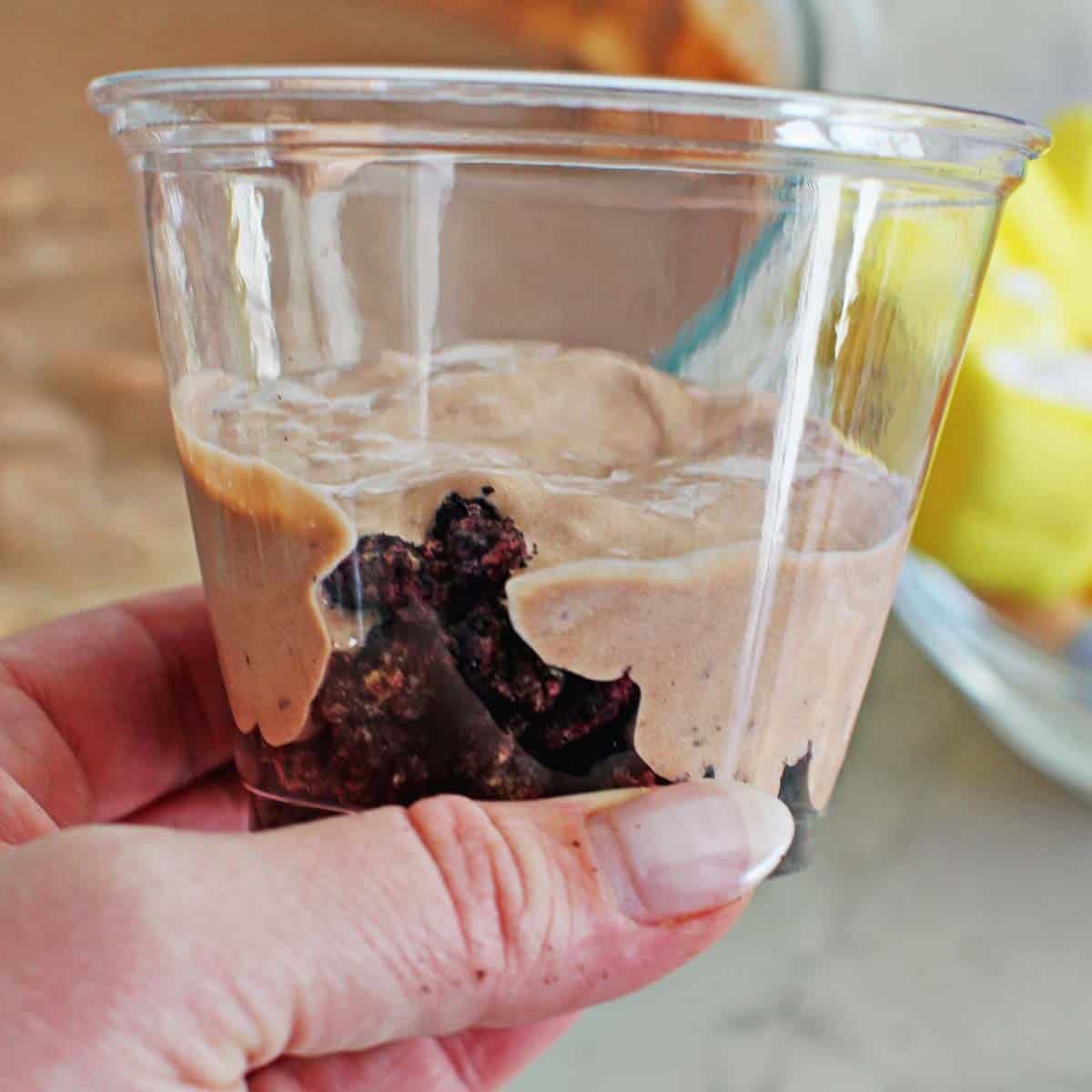 Clear cup filled with a layer of crushed oreos and chocolate pudding mix on top of it.