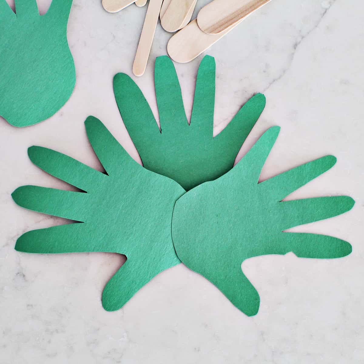 Three green handprints glued together.