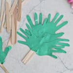 Green cut out handprints glued to popsicle sticks to make a palm branch.