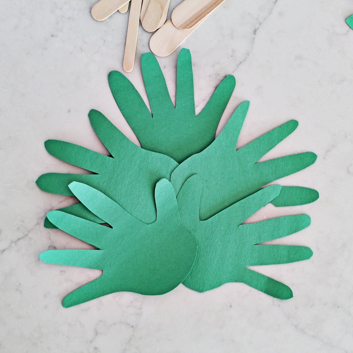 5 green handprints from construction glued together.