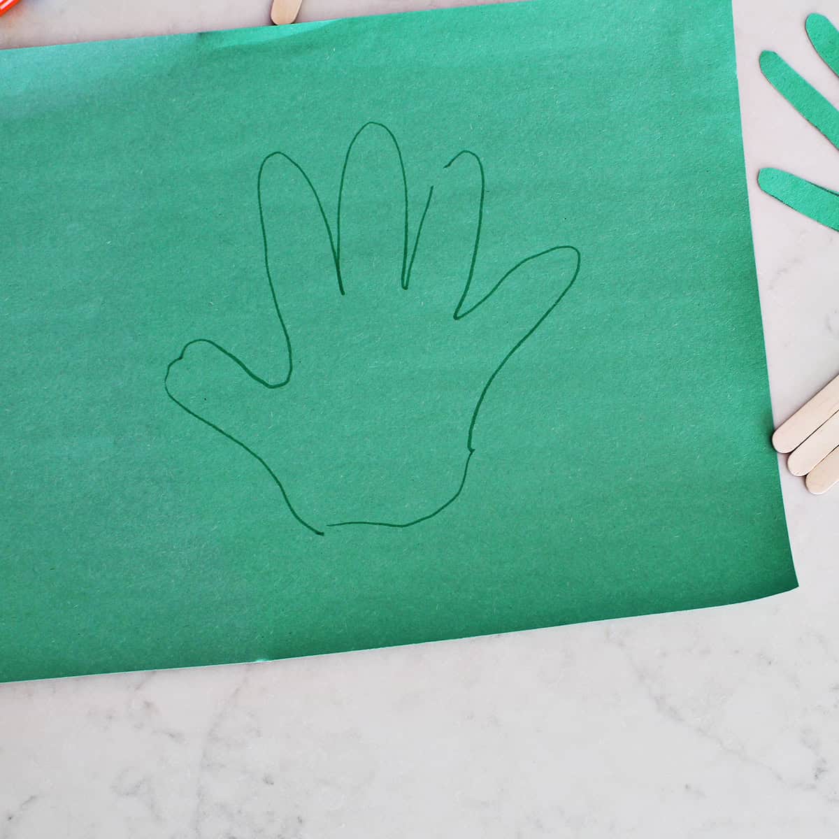 A green handprint traced onto a green piece of construction paper.
