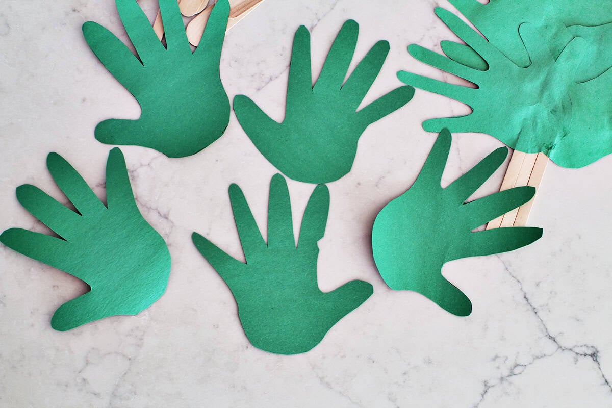 Five green handprints cut out of construction paper.