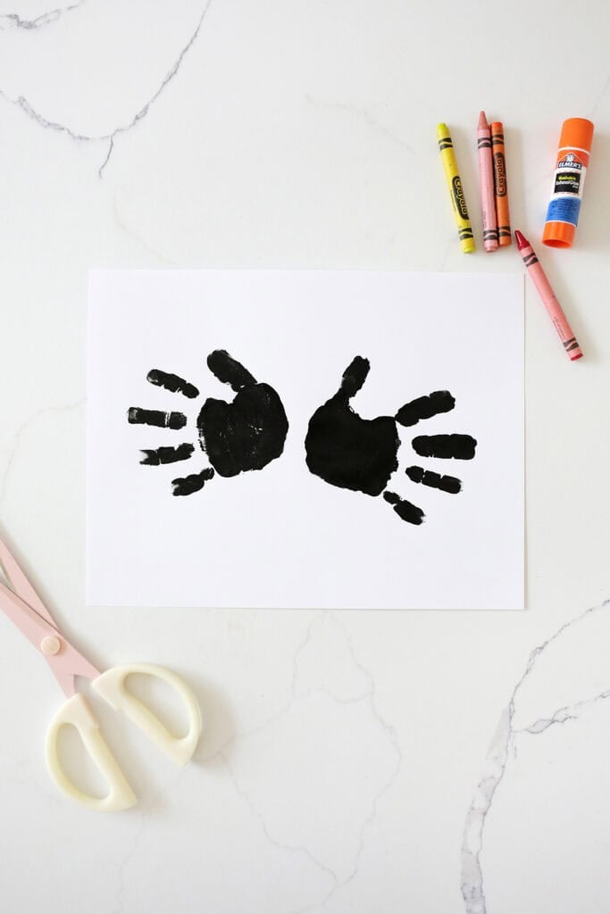 Two black handprints on a piece of paper.