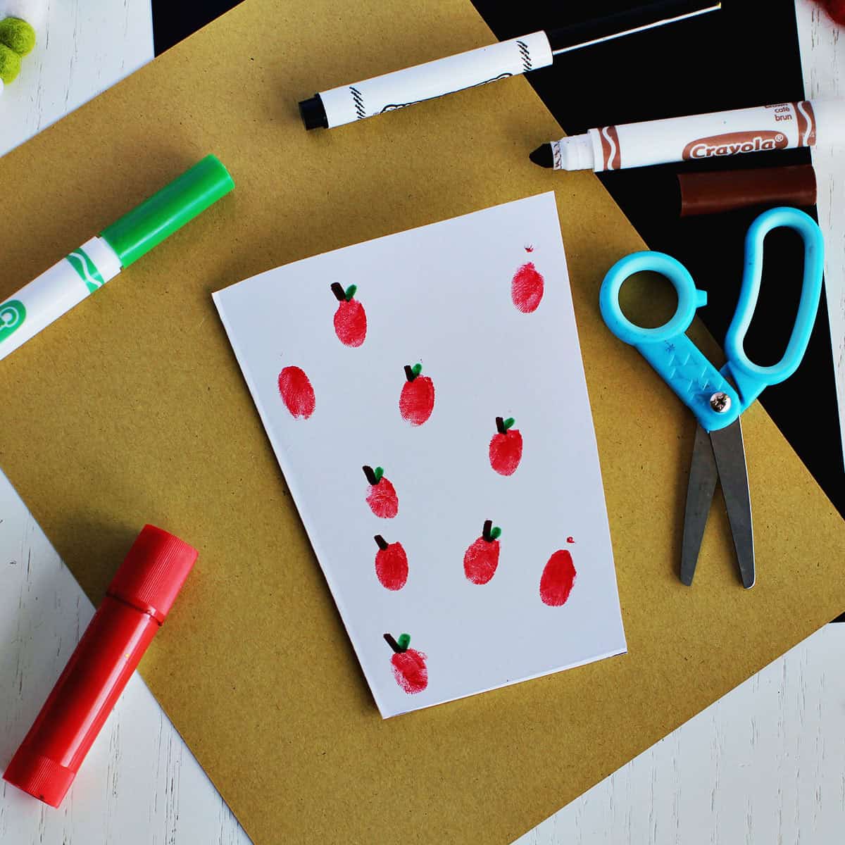 A coffee shaped card with red fingerprint dots that have stems and leaves added with markers.