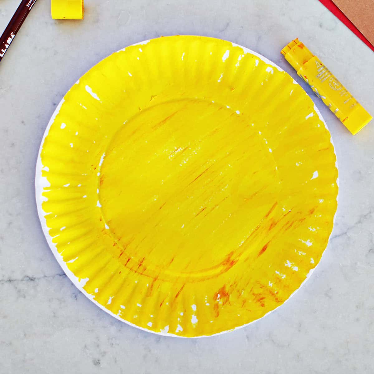 paper plate painted yellow on a counter.