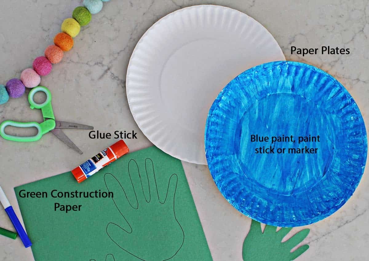 blue painted paper plate, green construction paper, gluestick, green and blue markers and green kid's scissors.