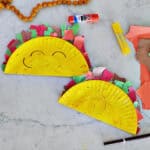 Two paper plates that have been painted yellow and decorated to look like a taco.