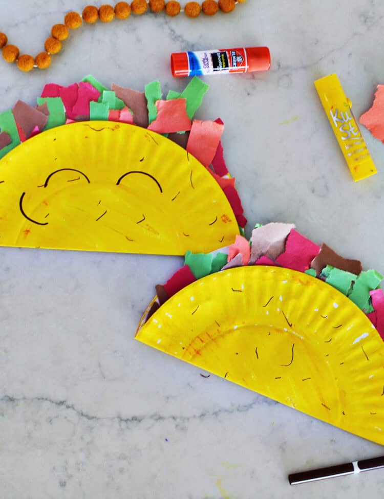 Two paper plates that have been painted yellow and decorated to look like a taco.