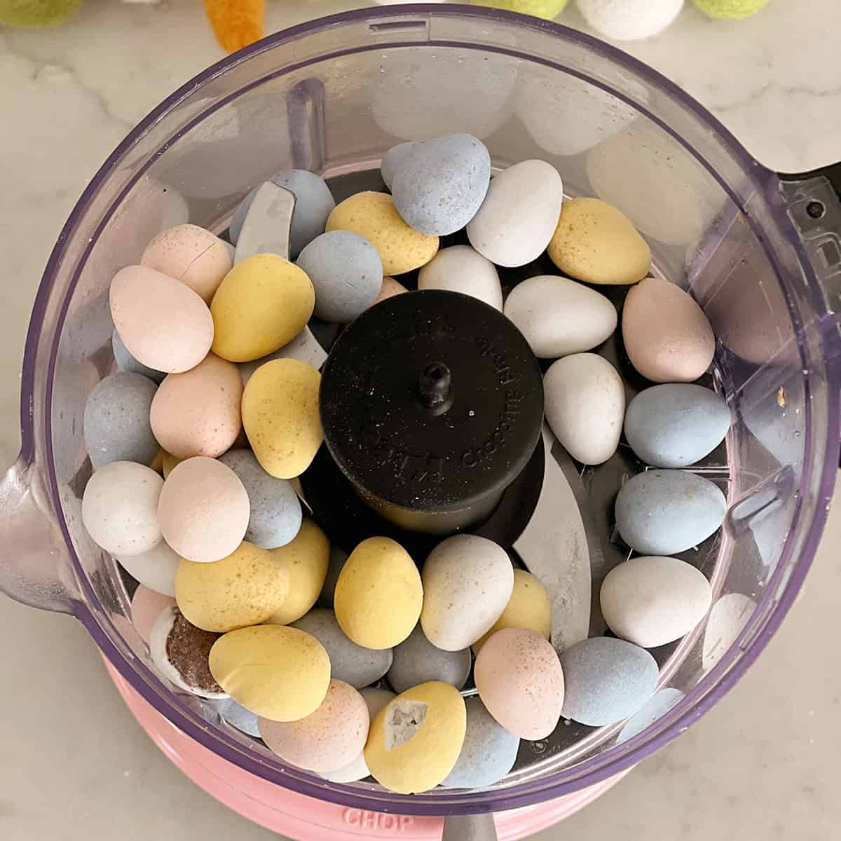 Food processor filled with cadbury egg candies.