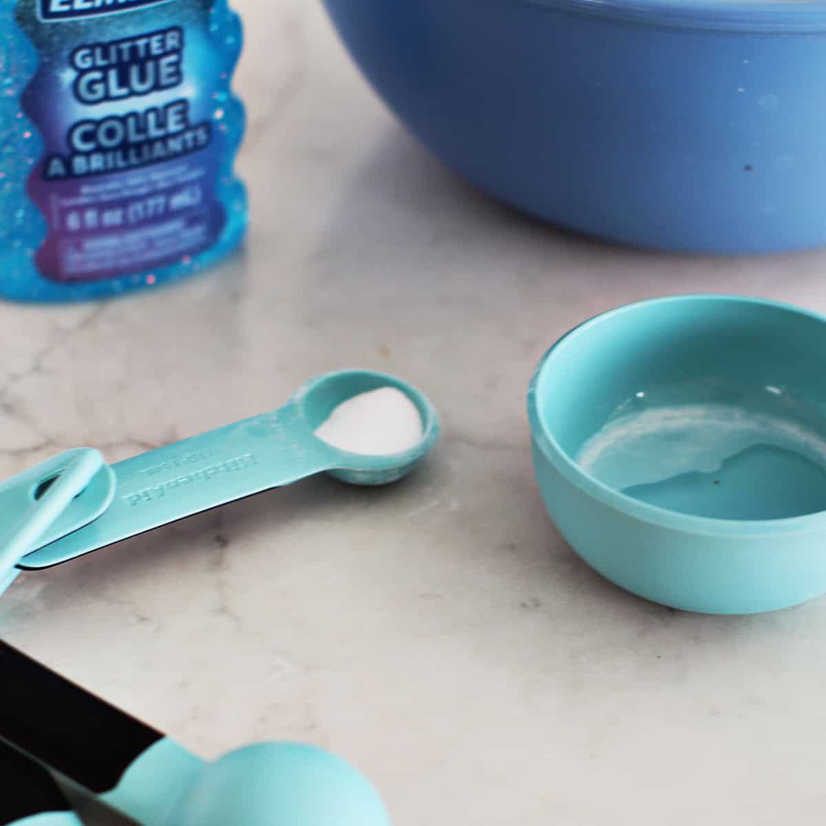 Baking soda in a measuring spoon on a counter.