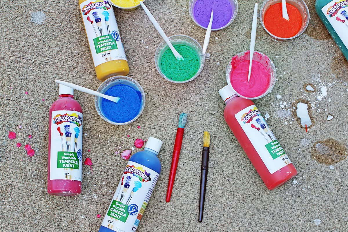 chalk paint made from tempera paint, water and cornstarch in various colors on the ground.