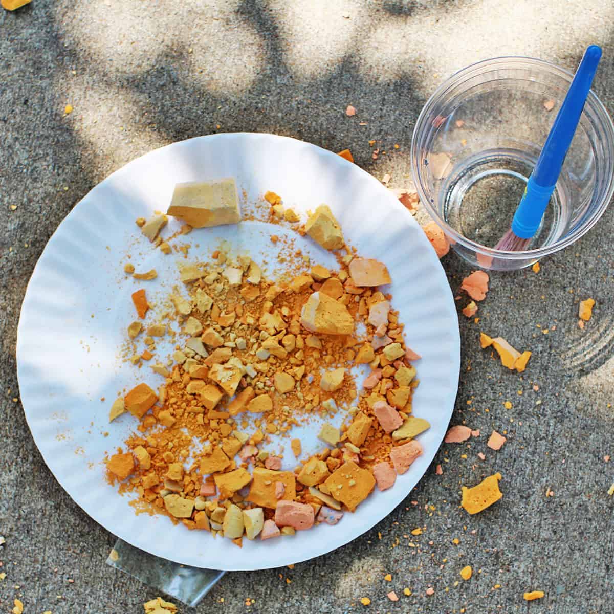 crushed chalk on a paper plate on the ground.