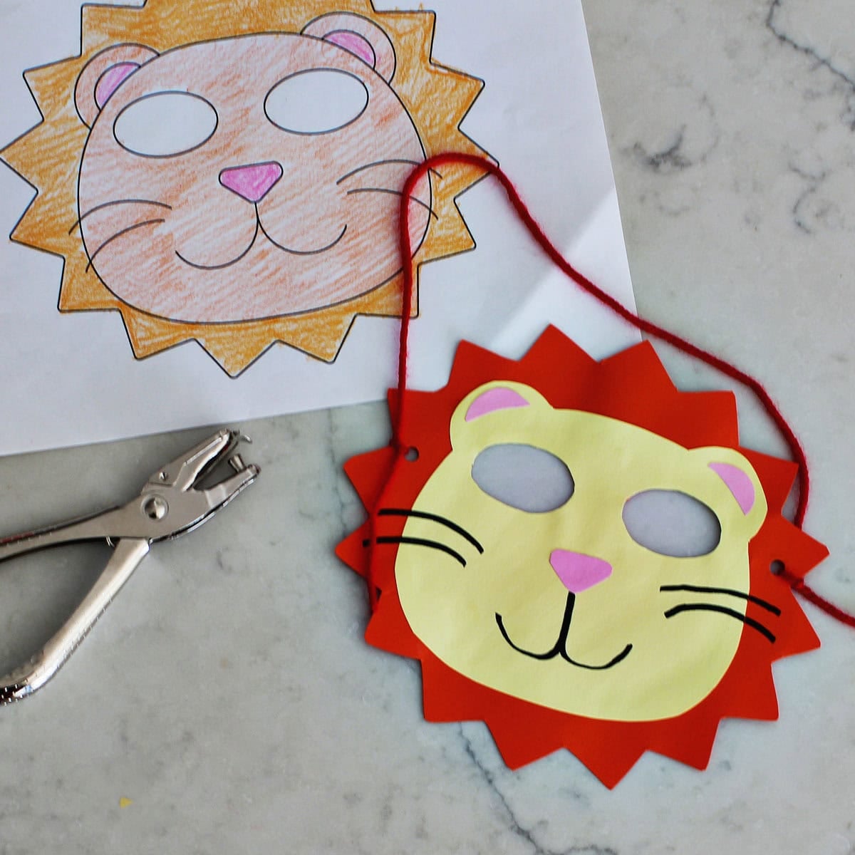 printed lion mask template next to kids mask made from cardstock and yarn.