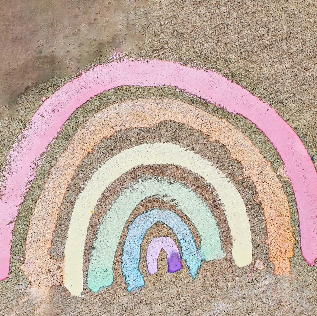 a rainbow painted with chalk paint on cement.