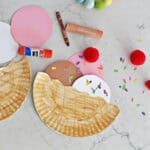 paper plate cut in half with paper circles cut out to make it look like ice cream in a bowl.
