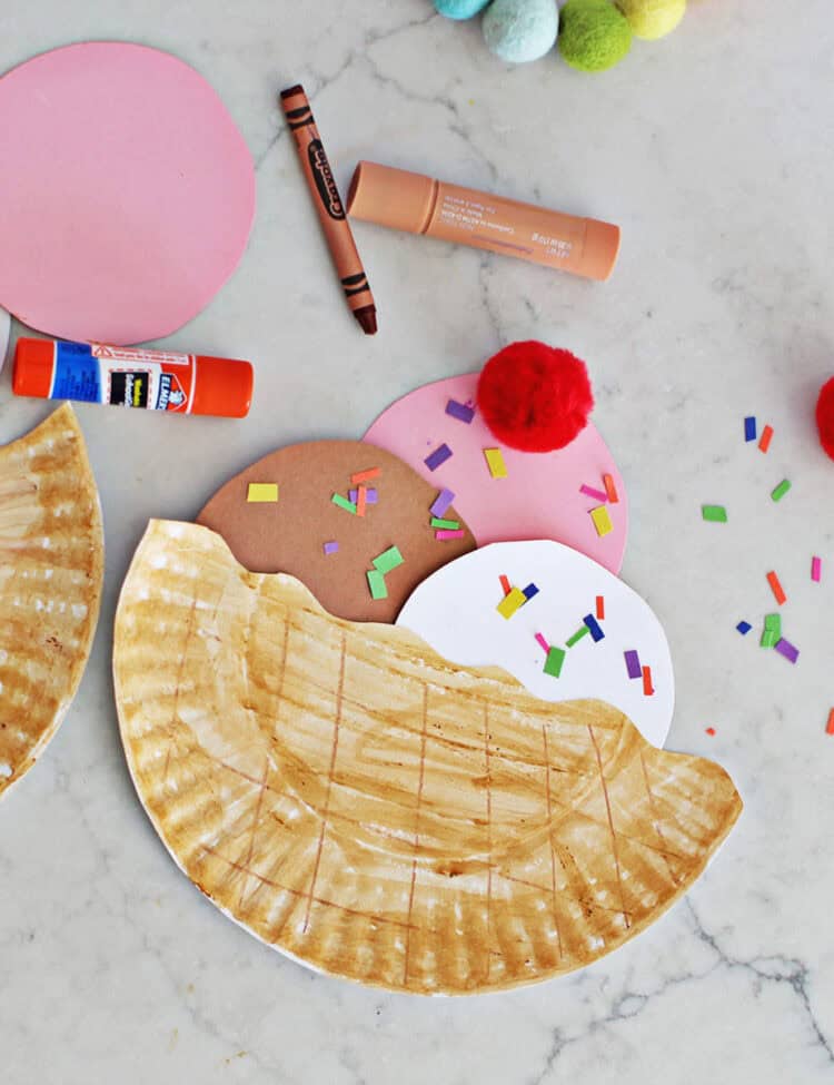 paper plate cut in half with paper circles cut out to make it look like ice cream in a bowl.