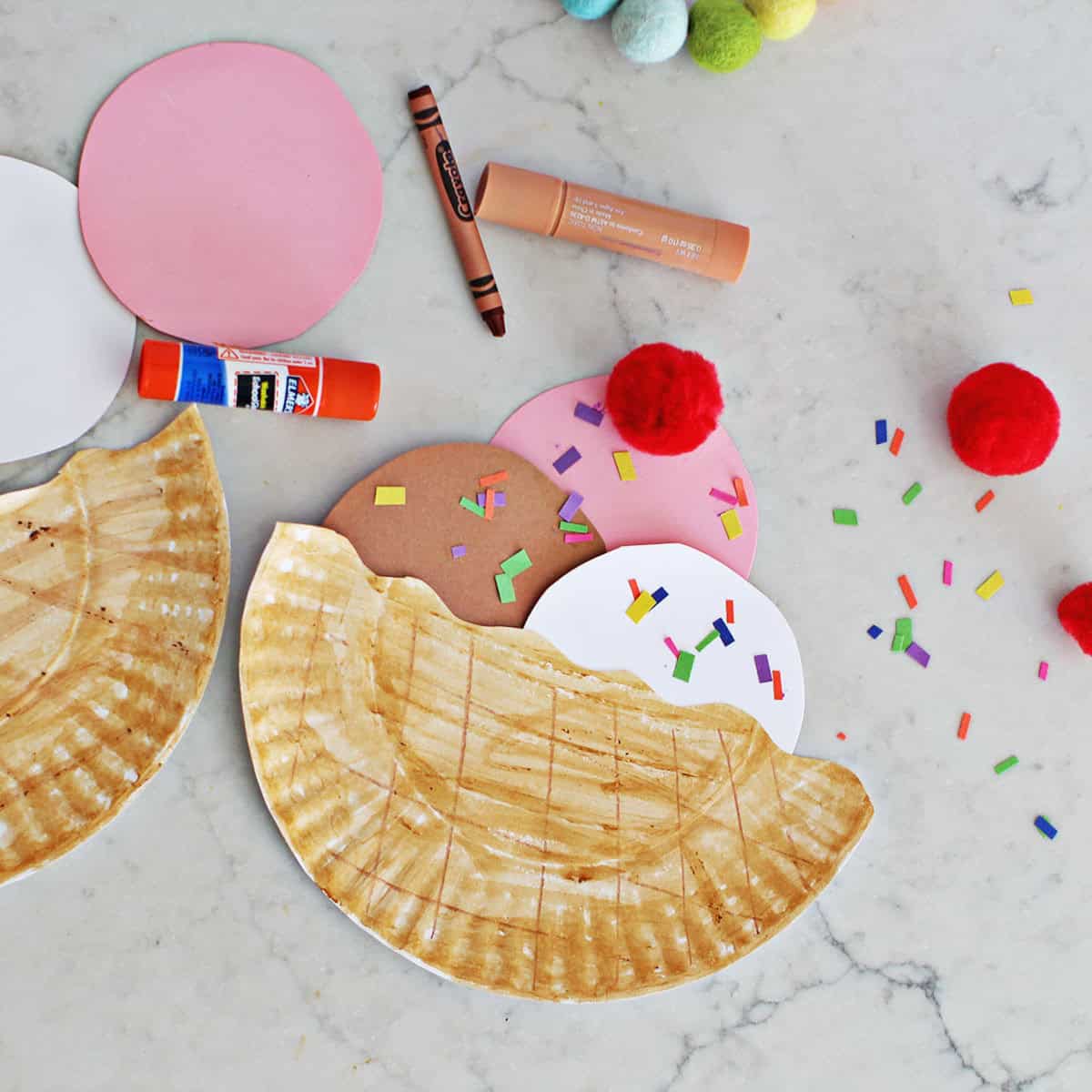 paper plate cut in half with paper circles cut out to make it look like ice cream in a bowl.
