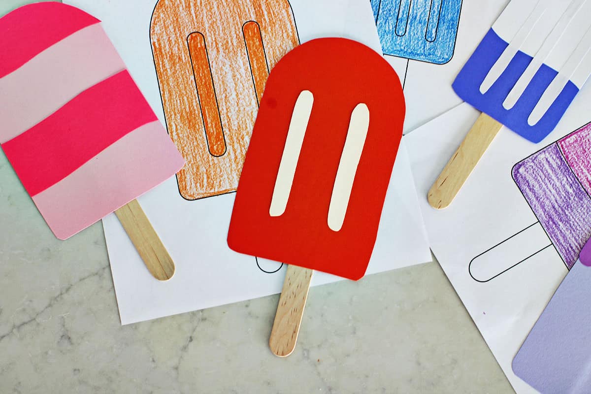 cardstock cut out into the shape of popsicles on a counter.