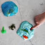 Child poking slime on a counter.
