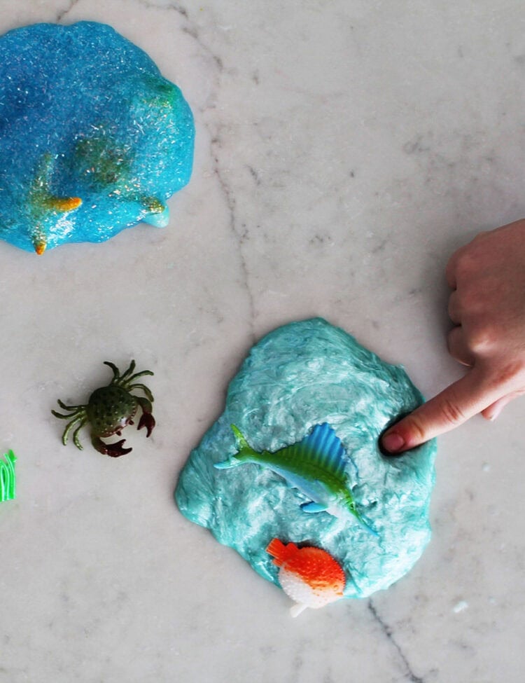 Child poking slime on a counter.