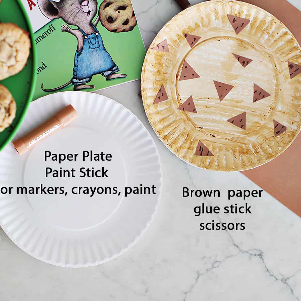 A paper plate, paint stick, paper plate made to look like a cookie, a book and a green plate with cookies on it.