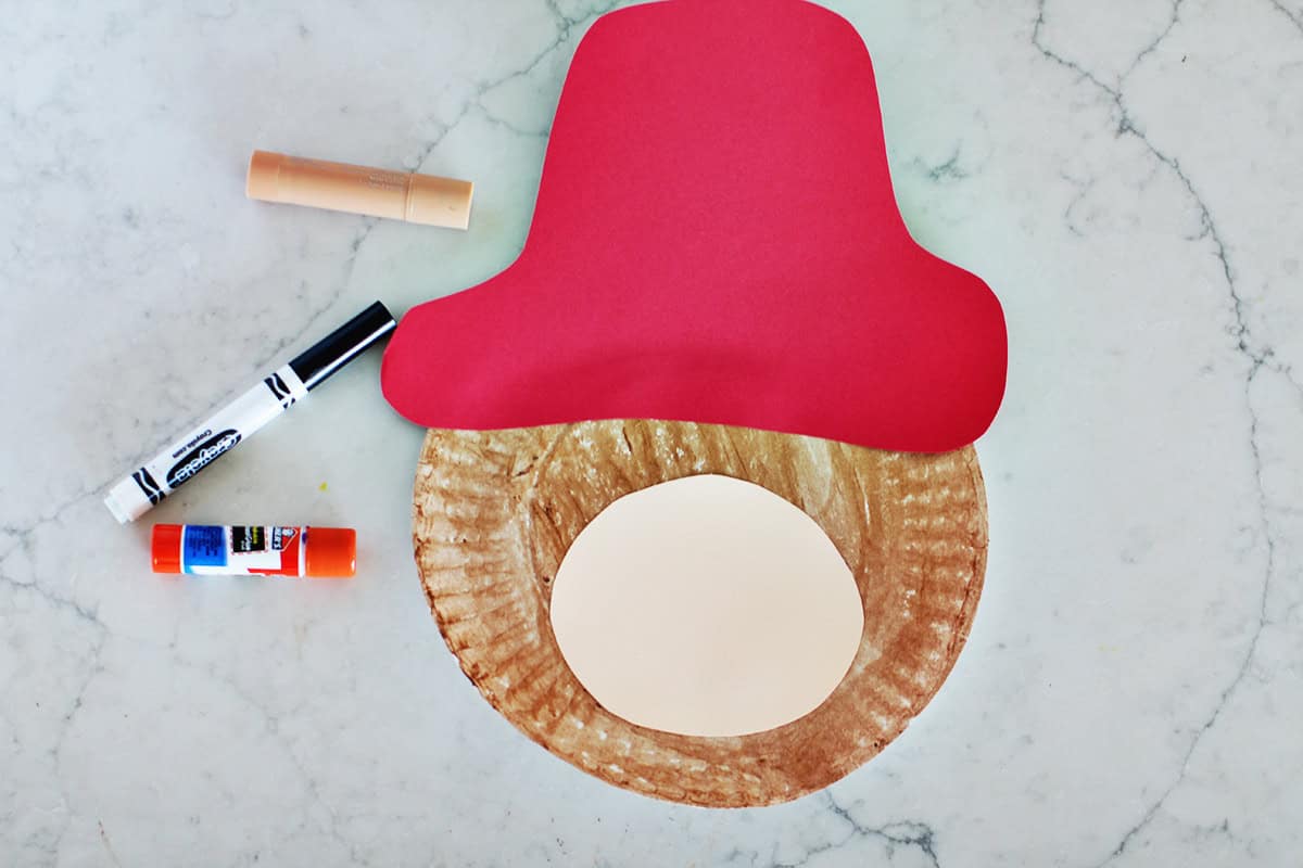 Red cardstock cut to look like a hat and a brown circle glued onto a plate.