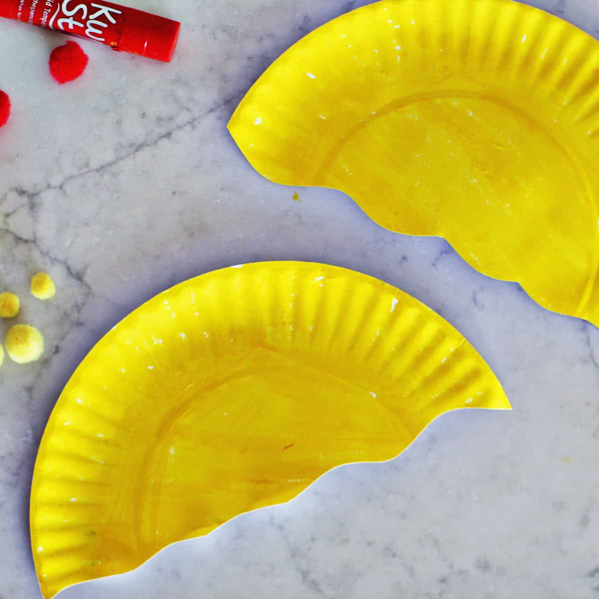two yellow halves of paper plates painted yellow.