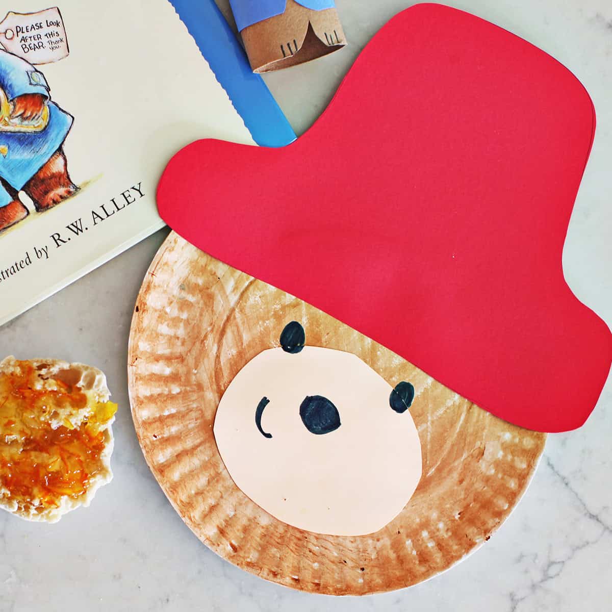 paper plate craft of Paddington Bear sitting next to a muffin with jam and the Paddington Bear book.