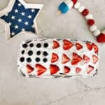 Overhead view of a pound cake topped with coolwhip, strawberries and blueberries to look like an American flag.